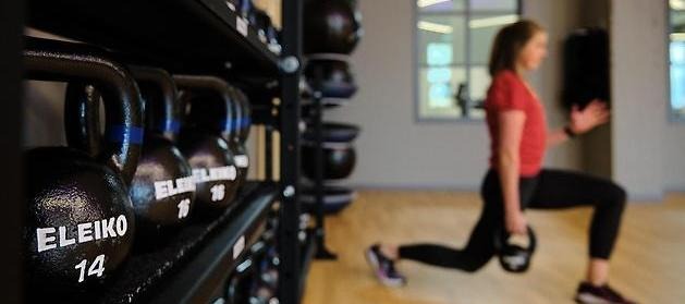 En kvinna i ett gym som tränar med vikter.