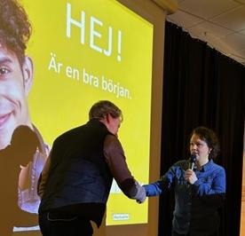 Föreläsning, med två som tar i hand