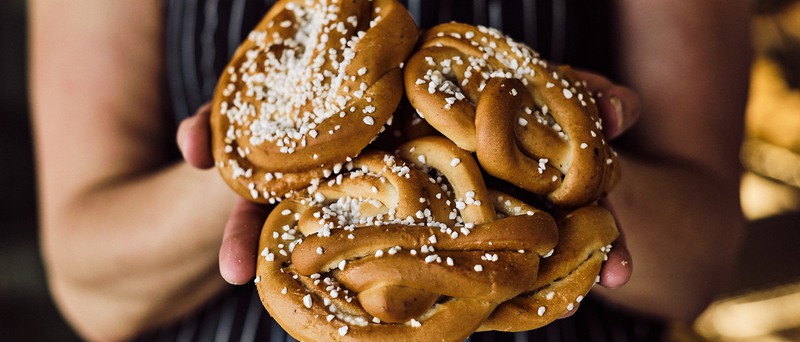 fyra kanelbullar som någon håller i händerna
