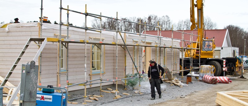 Bilden visar resning av en villa med en lyftkran