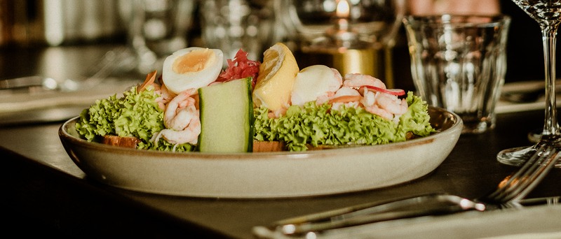 Närbild av en sallad med bland annat ägg och räkor.